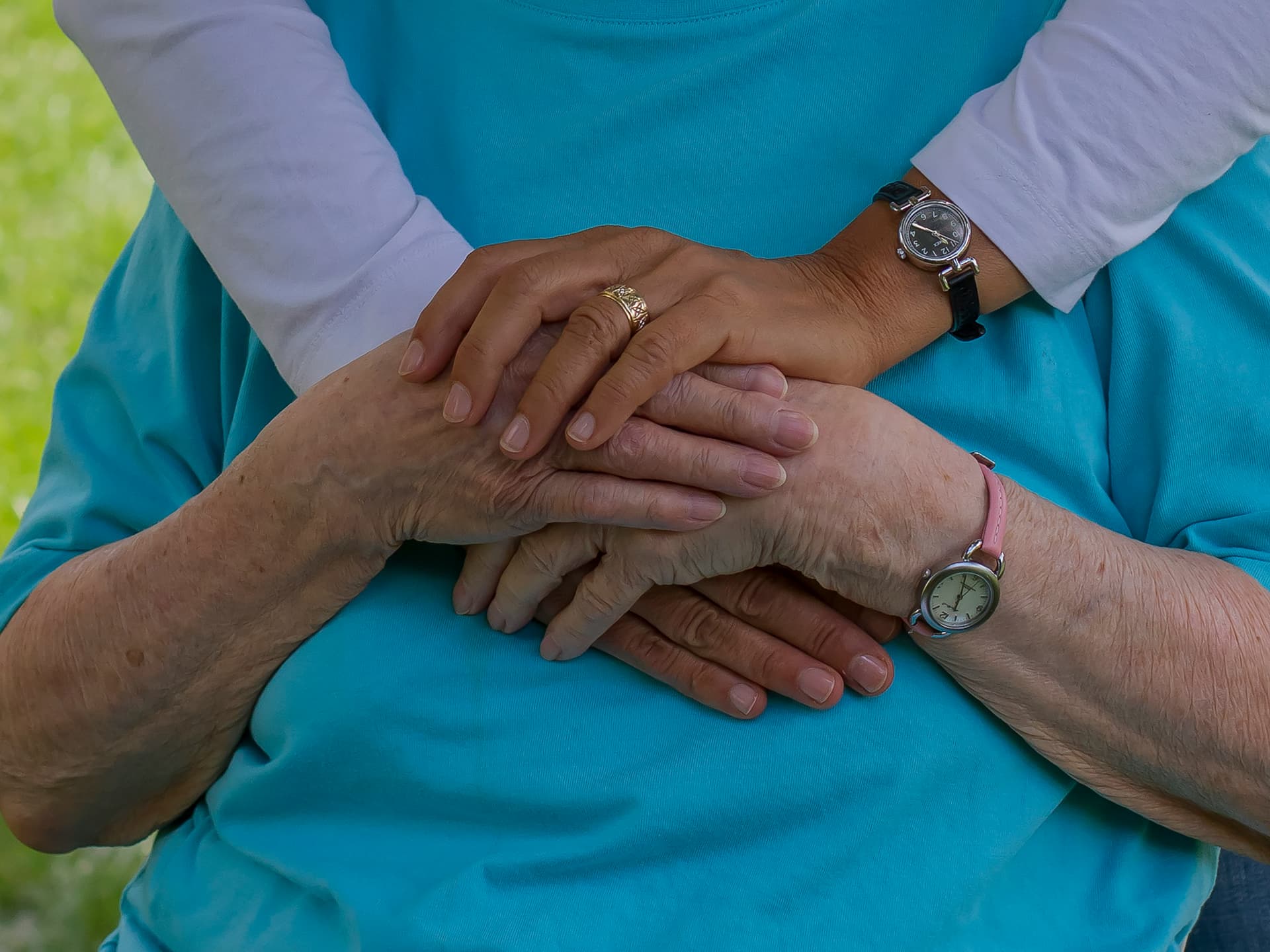 A support worker gently holding the hands of an older participant